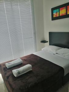 a large bed with two towels on top of it at APARTAMENTO TURISTICO PARQUE DEL CAFÉ -Precio Inigualable- in Montenegro