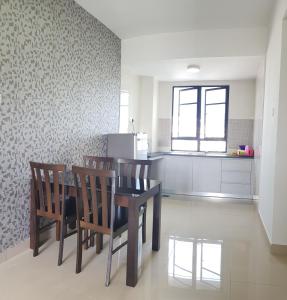 a dining room with a table and chairs in a kitchen at Family Staycation BYSS Homestay in Kampar
