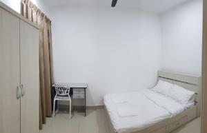 a bedroom with a bed and a desk and a chair at Family Staycation BYSS Homestay in Kampar