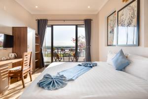 sypialnia z łóżkiem z biurkiem i balkonem w obiekcie Home River Villa w Hoi An