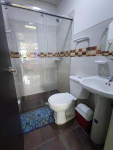 y baño con ducha, aseo y lavamanos. en Nirvana Casa de Huéspedes, en Melgar