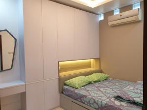 Dormitorio pequeño con cama y espejo en Guest House Omah Ningrat Bandung en Bandung