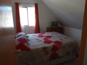 um quarto com uma cama com uma colcha em Colbun em Colbún