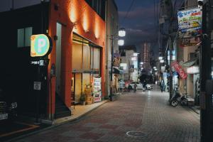 een stadsstraat 's nachts met mensen die over straat lopen bij TOKYO E JOY INN West Shinjuku Branch in Tokyo
