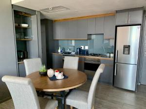 a kitchen with a table and chairs and a refrigerator at Umhlanga Arch 703 Sea View self-catering in Durban