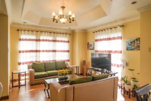 a living room with a couch and a tv at Charming Tagaytay Vacation Home in Tagaytay