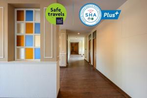 einen Flur in einem Krankenhaus mit einem Schild, auf dem steht, dass Safe reist und Shea plus in der Unterkunft Grand Hotel Buriram in Buriram