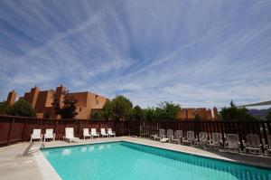 a swimming pool with chairs and a fence at Kokopelli's Kiva #3230 in Moab