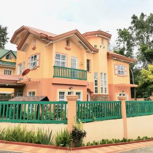 a house with a green fence at Charming Tagaytay Vacation Home in Tagaytay