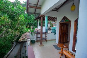 a porch of a house with a table and chairs at Green Villa Apartment in Unawatuna