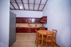 uma cozinha com uma mesa de madeira e cadeiras em Green Villa Apartment em Unawatuna