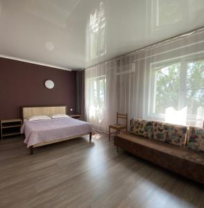 ゲレンジークにあるGolubaya Bukhta Art-hotelのベッドルーム(ベッド1台、ソファ付)
