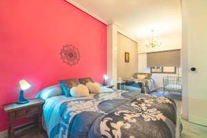 Un dormitorio con una pared roja y una cama en Casa El Trinquete, en Cenicero