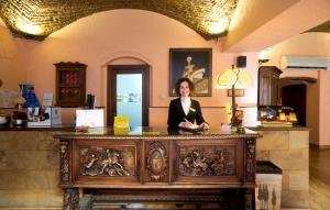 a woman is standing behind a table in a store at Hotel Don Carlos Cáceres in Cáceres