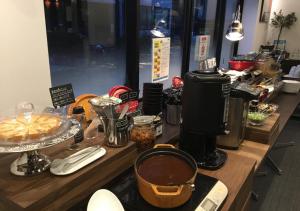 a counter with a counter top with coffee makers and food at APA Hotel Shin Osaka Ekiminami in Osaka
