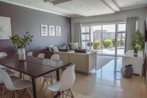 uma sala de estar com uma mesa e um sofá em Exclusive Poolside Villa, Humewood em Port Elizabeth