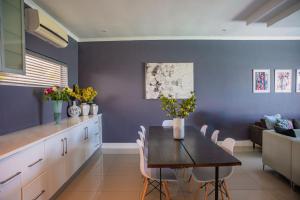 a kitchen and dining room with a table and chairs at Exclusive Poolside Villa, Humewood in Port Elizabeth