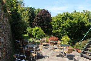 een groep tafels en stoelen op een patio bij Marton Guest House in St Peter Port