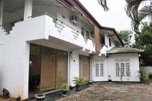 una casa bianca con piante in vaso davanti di The Sisara a Kataragama