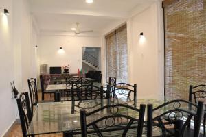 卡塔拉伽馬的住宿－The Sisara，一间设有玻璃桌和椅子的用餐室