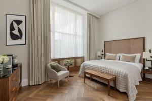 a hotel room with a bed and a chair at The Queens Gate Hotel in London