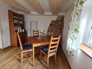 a dining room with a wooden table and chairs at Ferienhaus Landpause in Frohburg +6 photos