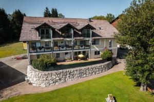 eine Luftansicht eines großen Hauses mit einer Steinmauer in der Unterkunft Voralpenhotel Schmoller in Sankt Georgen im Attergau