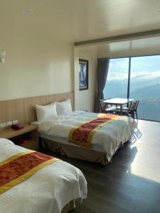 a hotel room with two beds and a table at Song Mao Homestay in Leye