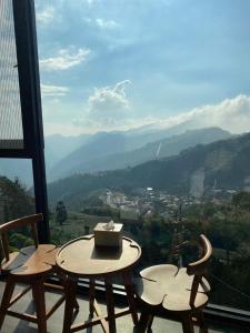 a table and chairs on a balcony with a view at Song Mao Homestay in Leye