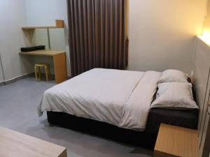 a bedroom with a bed and a desk in a room at CAMERON TROPICA HOMESTAY in Cameron Highlands