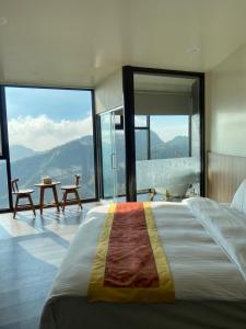 a bedroom with a large bed with a view of the mountains at Song Mao Homestay in Leye