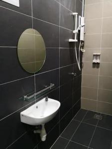 uma casa de banho com um lavatório e um espelho em CAMERON TROPICA HOMESTAY em Cameron Highlands