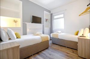 1 dormitorio con 2 camas y TV. en 4 Bed Executive Style House - Near City Centre en Swansea