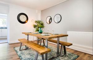 a dining room with a table and mirrors on the wall at 4 Bed Executive Style House - Near City Centre in Swansea