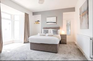 a bedroom with a bed and a large window at 4 Bed Executive Style House - Near City Centre in Swansea +12 photos