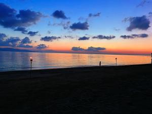 a sunset on a beach with the water and clouds at Sea Love Beach Bar & Bungalows in Ban Tai