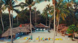 a resort with palm trees and people on the beach at Sea Love Beach Bar & Bungalows in Ban Tai