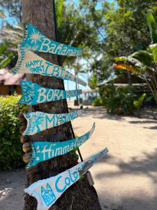 a sign on a tree with signs on it at Sea Love Beach Bar & Bungalows in Ban Tai