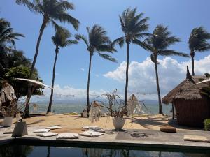 a resort with palm trees and a swimming pool at Sea Love Beach Bar & Bungalows in Ban Tai