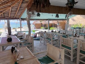 a restaurant with tables and chairs in front of the ocean at Sea Love Beach Bar & Bungalows in Ban Tai