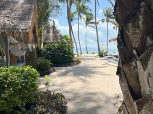 a pathway leading to a beach with palm trees at Sea Love Beach Bar & Bungalows in Ban Tai
