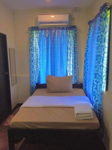 Cama en habitación con cortinas azules en The Family Farm Stay en Ciudad de Cauayán