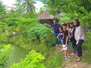 a group of people standing in front of a river at The Family Farm Stay in Cauayan City