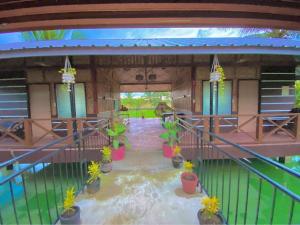 a house with a patio with potted plants in it at The Family Farm Stay in Cauayan City +19 photos