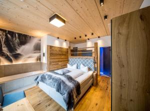 Un dormitorio con una cama con una manta azul. en Post Hotel Paznaun, en See