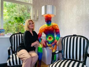 a woman is sitting next to a colorful statue at The 25 Boutique B&B - Adults Only in Torquay