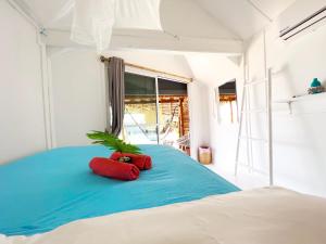 Una cama con dos almohadas rojas y una planta. en Sea Love Beach Bar & Bungalows, en Baan Tai