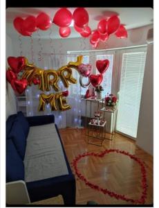 una stanza con un mucchio di palloncini rossi e dorati di ANKA apartman a Smederevo