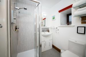 a bathroom with a shower and a sink and a toilet at Ceol na Mara Guest House in Tarbert