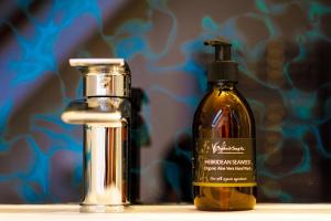 a bottle of oil next to a dispenser and a vile at Ceol na Mara Guest House in Tarbert